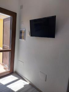 a flat screen tv on a wall with a window at Domus Vida in Quartu Sant'Elena