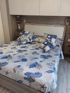 a bed with a blue and white blanket and pillows at Domus Vida in Quartu Sant'Elena