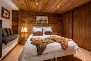 a bedroom with a bed in a room with wooden walls at La Ferme 1828 in Demi-Quartier
