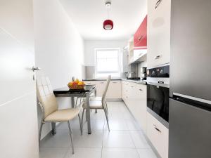 a white kitchen with a table and chairs at Brasov Altipiani Apartments in Braşov