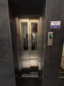 an elevator with three glass doors in a building at Sai Meridian in Pondicherry
