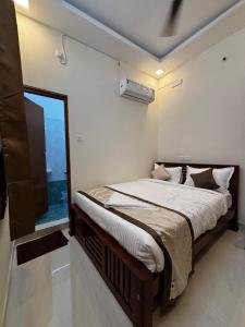 a bedroom with a large bed with a window at Sai Meridian in Pondicherry