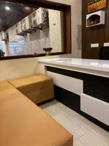 a kitchen with a counter with a brown stool at Sai Meridian in Pondicherry