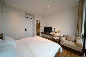 a bedroom with a large white bed and a couch at ANNA Boutique Villa - Sea View in Phan Thiet