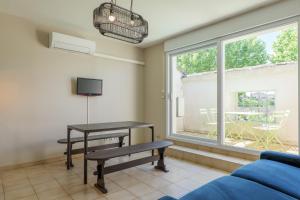 a living room with a table and a window at Gîtes du Parc in Vallon-Pont-dʼArc