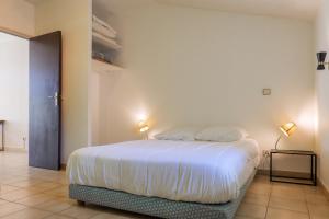 a bedroom with a bed with white sheets and two lamps at Gîtes du Parc in Vallon-Pont-dʼArc +74 photos