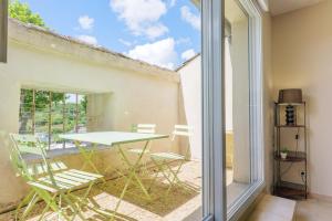 a patio with a table and chairs on a balcony at Gîtes du Parc in Vallon-Pont-dʼArc