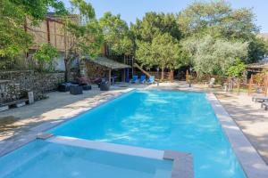 a large blue swimming pool in a yard at Gîtes du Parc in Vallon-Pont-dʼArc