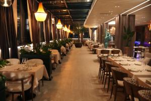 a dining room with white tables and chairs at Alegria Hotel in Prizren