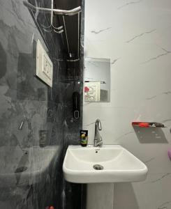 a bathroom with a white sink and a mirror at SS Hostel Siliguri in Siliguri