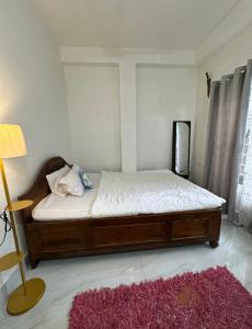a bedroom with a bed and a red rug at SS Hostel Siliguri in Siliguri