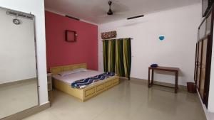a bedroom with a bed and a green curtain at LlBRA REGENCY in Guruvāyūr +2 photos