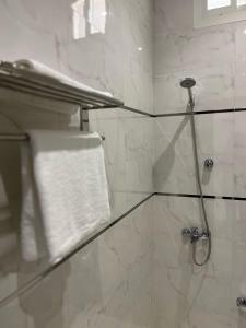 a bathroom with a shower with a white towel at شقق وجهة الوصول in Ar Rawshān +16 photos