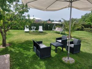 a group of chairs and an umbrella in a yard at Vista Mare in Nea Irakleia