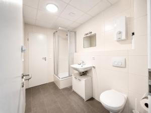 a white bathroom with a toilet and a sink at HanseStay Wandsbek in Hamburg