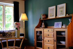 a living room with a green wall and a dresser at Judies Garten in Schaalby