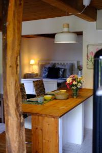 a kitchen with a counter with chairs and flowers on it at Judies Garten in Schaalby +12 photos
