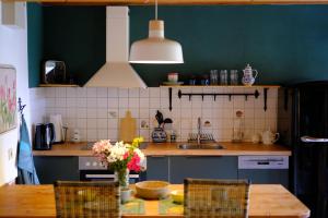 a kitchen with a wooden table and a green wall at Judies Garten in Schaalby
