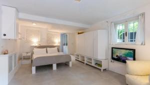 a white bedroom with a bed and a tv at VILLA CORONA 8, Emma Villas in Cattolica +29 photos