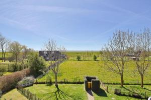 a view of a field with trees and a fence at Süderhafen 2c in Nordstrand