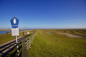 a sign on the side of a road near the water at Süderhafen 2c in Nordstrand