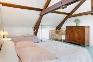 a attic bedroom with two beds and a crib at Chambres D'hotes Vignolo in Pontiacq-Viellepinte