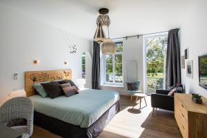 En eller flere senge i et værelse på Le 49 Côté Parc & SPA