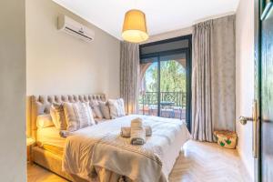 a bedroom with a large bed with a large window at Atlas Views Appartements avec Piscine Golf de Marrakech in Marrakesh +87 photos