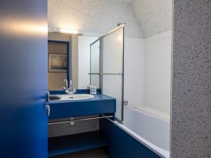 a bathroom with a blue sink and a shower at Ker Envor in Pleumeur-Bodou