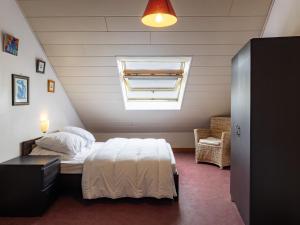 a bedroom with a white bed and a window at War Ar Maez in Pleumeur-Bodou