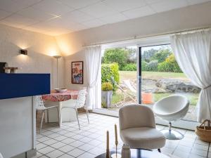a living room with a table and chairs and a large window at Ker Envor in Pleumeur-Bodou +22 photos