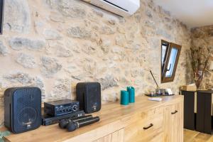 a room with a counter with speakers and a stone wall at Vagalume in Vedra +17 photos