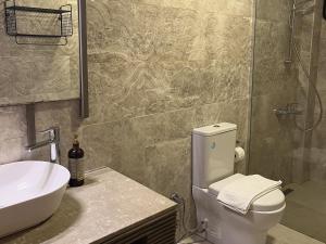 a bathroom with a white toilet and a sink at Melinda Pension & Restaurant in Mesudiye