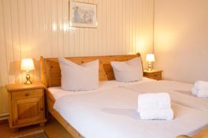 a bedroom with two beds with white pillows and two lamps at Seetuun-Hoff - Studio in Nordstrand