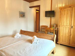 a bedroom with two beds and a table and a television at Seetuun-Hoff - Studio in Nordstrand