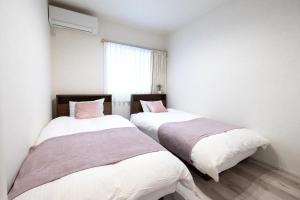 two beds in a small room with a window at HOTEL StayLuck KOTOHIRA - 琴平駅徒歩4分 in Kotohira +96 photos