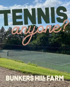 a tennis court with the words tennis envy burners hill farm at Bunkers Hill Farm in Bramfield