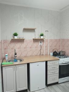 a kitchen with a sink and a stove at Строитель 39 in Oral
