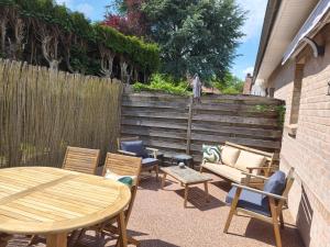 a patio with a table and chairs and a fence at Trésor de Beaurains in Beaurains
