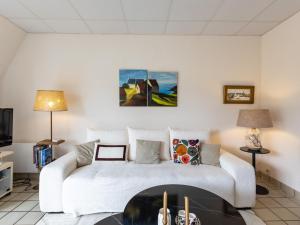 a living room with a white couch and a fireplace at Ker Envor in Pleumeur-Bodou