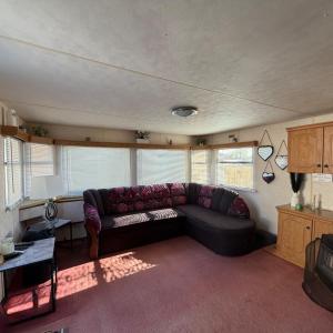 a living room with a couch and some windows at Static Caravan Sleeps 8 with Indoor Pool in Clacton-on-Sea