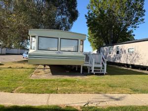 a tiny house is parked in a yard at Static Caravan Sleeps 8 with Indoor Pool in Clacton-on-Sea