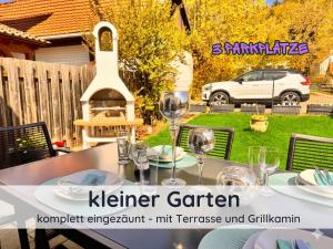 a table with wine glasses on it in a backyard at Der Fuchsbau - Ferienwohnung "Auszeit Harz" - 3 Hunde willkommen - eingezäunter Garten in Bad Sachsa