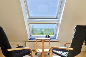 a room with two chairs and a table and a window at Süderhafen 2c in Nordstrand
