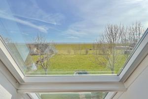 a window in a house with a view of a field at Süderhafen 2c in Nordstrand +34 photos