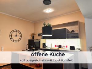 a kitchen with a counter and a clock on the wall at Der Fuchsbau - Ferienwohnung "Auszeit Harz" - 3 Hunde willkommen - eingezäunter Garten in Bad Sachsa
