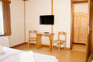 a room with a table and chairs and a tv at Seetuun-Hoff - Dree in Nordstrand