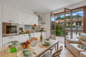 a kitchen and living room with a table and a couch at Juliette House: Shared Pool & Relax - Happy Rentals in Salò