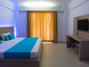 a bedroom with a bed and a desk with a computer at Vergina Sun in Faliraki