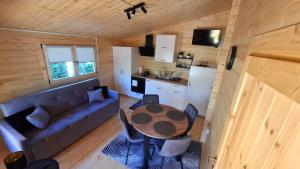 a living room with a couch and a table and a kitchen at Zacisze domek z Jacuzzi & Sauna in Chrołowice